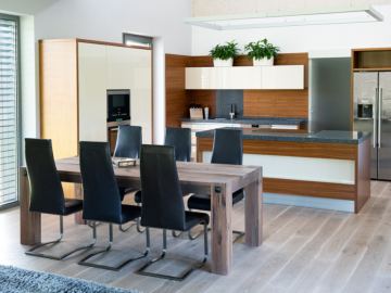 Moderní kuchyňský nábytek spojený s jídelním stolem.